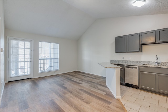 kitchen with dishwasher, light hardwood / wood-style floors, light stone counters, sink, and lofted ceiling