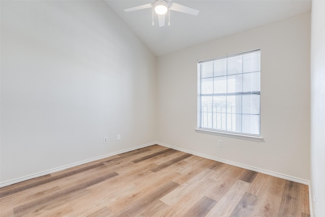 empty room featuring ceiling fan, light hardwood / wood-style flooring, vaulted ceiling, and a wealth of natural light