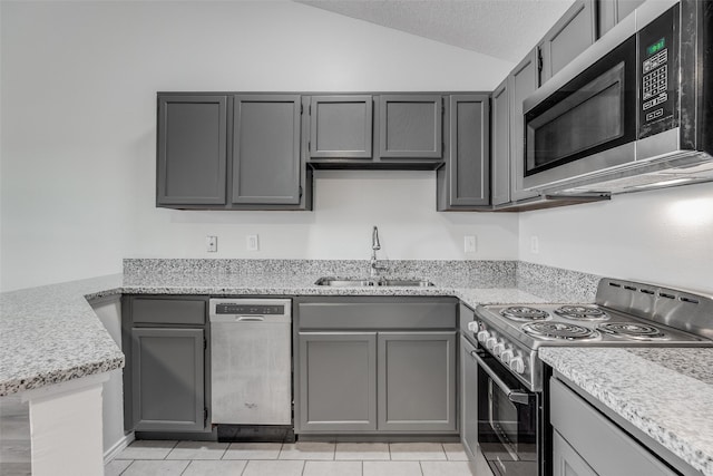 6108 Abrams Rd Unit 424, Dallas, TX 75231 - kitchen featuring appliances with stainless steel finishes, gray cabinetry, a sink, vaulted ceiling, and light tile patterned flooring