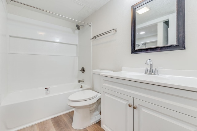 full bathroom with a textured ceiling, shower / washtub combination, vanity, and wood-type flooring