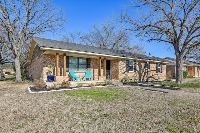 ranch-style house with brick siding, a porch, and a front yard