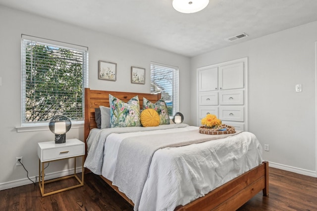 bedroom featuring baseboards, visible vents, and dark wood-style flooring