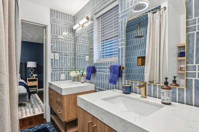 bathroom featuring a shower with shower curtain, ensuite bath, two vanities, and a sink