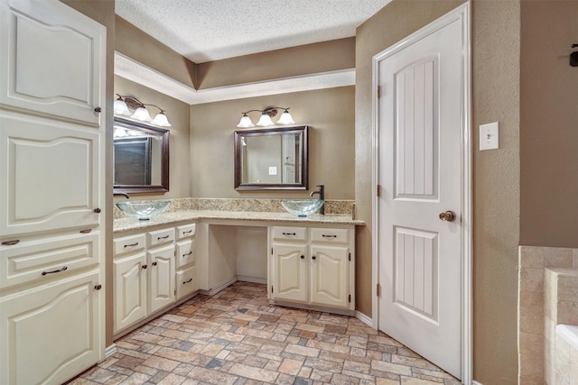 bathroom featuring a textured ceiling and vanity