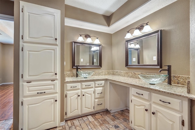 bathroom with a textured ceiling and vanity