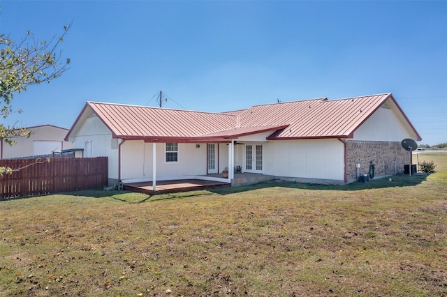 back of property featuring french doors, a patio, and a lawn