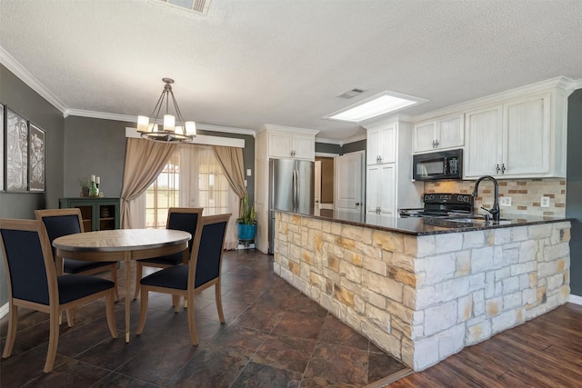 kitchen featuring black appliances, an inviting chandelier, crown molding, white cabinetry, and sink