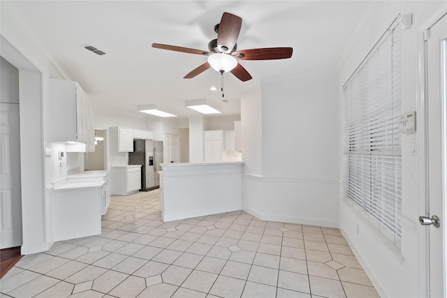 interior space with ceiling fan and crown molding