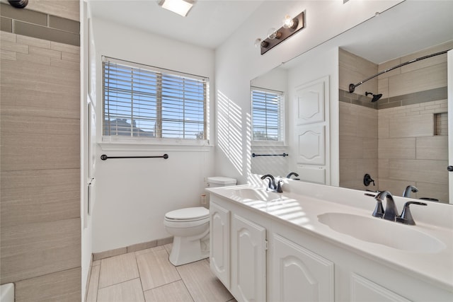 bathroom featuring toilet, vanity, tile patterned flooring, and tiled shower