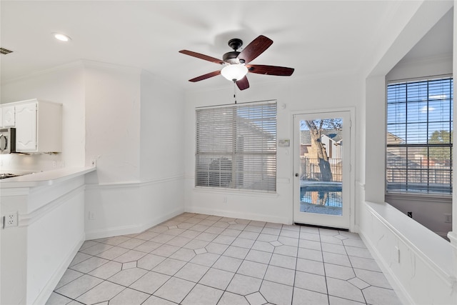 unfurnished dining area with ornamental molding, ceiling fan, and light tile patterned flooring