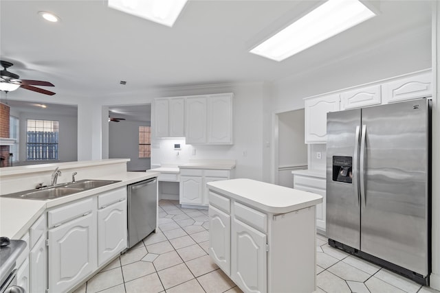 kitchen featuring stainless steel appliances, a center island, ceiling fan, white cabinets, and sink