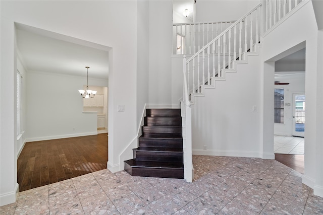 stairway featuring an inviting chandelier and ornamental molding