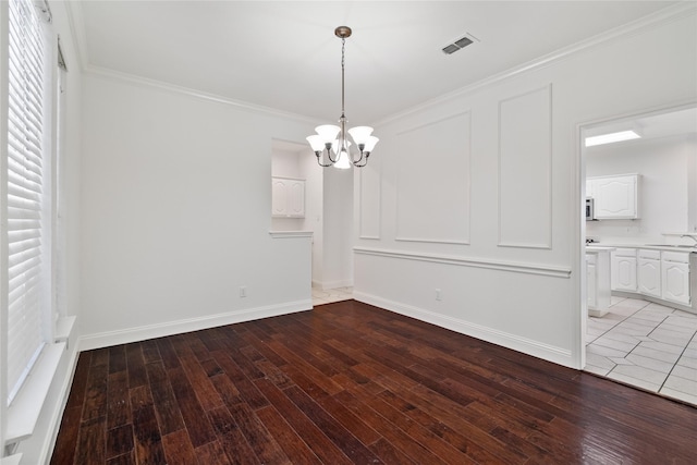 unfurnished dining area featuring a notable chandelier, crown molding, wood-type flooring, and sink