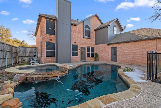 view of swimming pool with an in ground hot tub