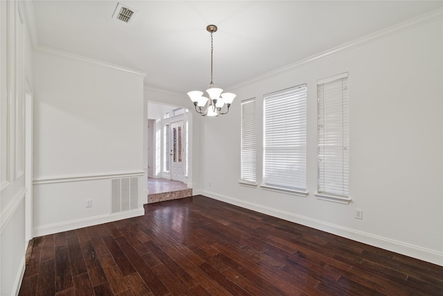 spare room featuring an inviting chandelier, ornamental molding, a healthy amount of sunlight, and hardwood / wood-style floors