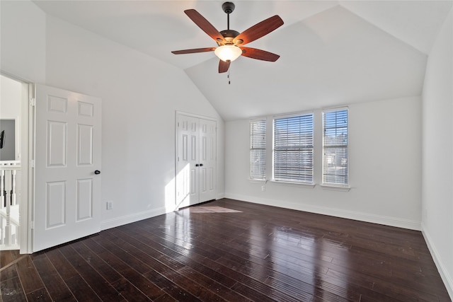 interior space with ceiling fan, vaulted ceiling, and dark wood-type flooring