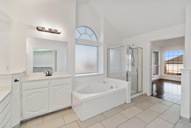 bathroom with lofted ceiling, separate shower and tub, and vanity