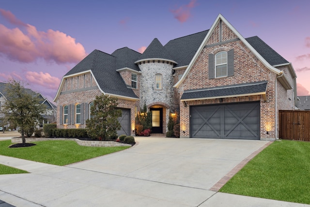 view of front of home with a garage and a lawn