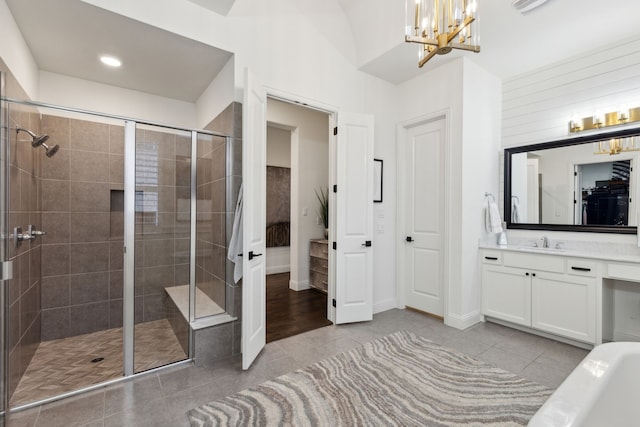 bathroom with vanity, tile patterned floors, plus walk in shower, and an inviting chandelier