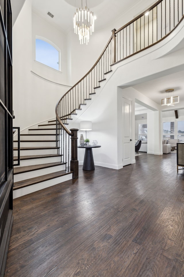 foyer entrance with dark hardwood / wood-style flooring, a high ceiling, and a wealth of natural light