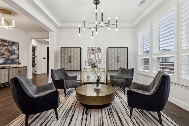 living room featuring hardwood / wood-style flooring, crown molding, and a chandelier