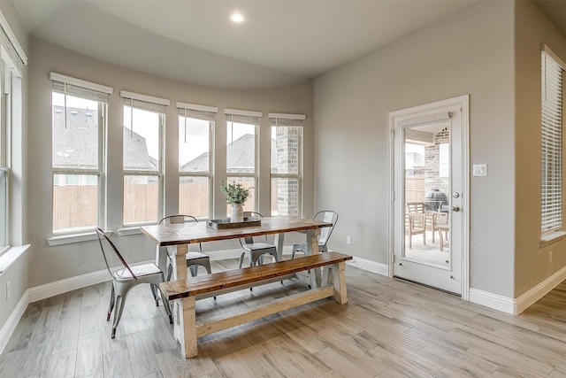 dining space featuring lofted ceiling and light wood-type flooring