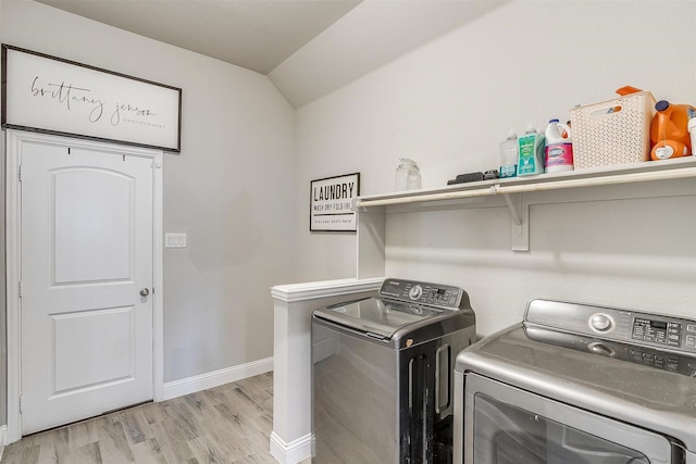 laundry area featuring washing machine and dryer and light hardwood / wood-style flooring