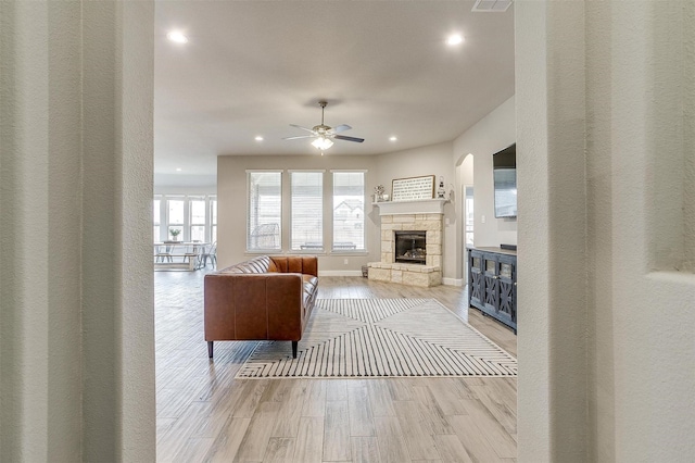 living room with a fireplace and ceiling fan