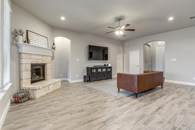 unfurnished living room featuring a fireplace, light wood-type flooring, and ceiling fan