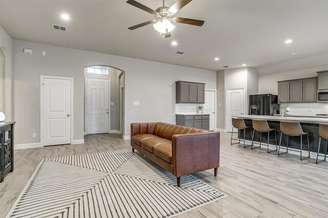 living room with ceiling fan and light hardwood / wood-style flooring