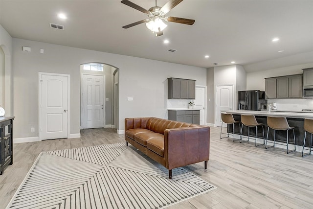 living room featuring ceiling fan and light hardwood / wood-style flooring