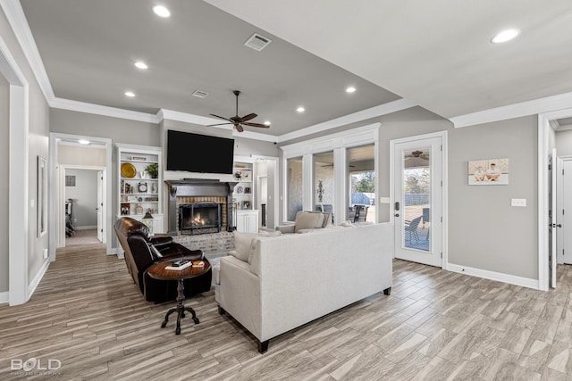 living room with a fireplace, light wood-type flooring, ceiling fan, and ornamental molding