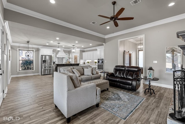 living room with ornamental molding, ceiling fan, light hardwood / wood-style floors, and a healthy amount of sunlight