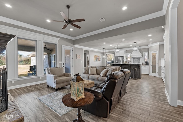 living room featuring ceiling fan and crown molding