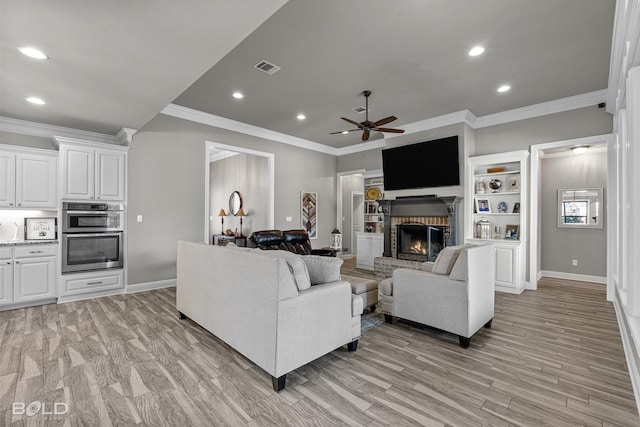 living room with a fireplace, ceiling fan, crown molding, and light hardwood / wood-style flooring