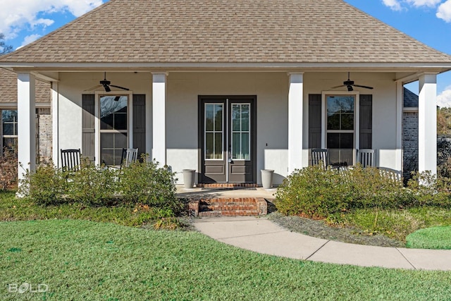 entrance to property featuring a porch, a yard, and ceiling fan