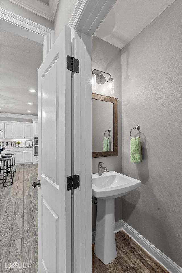 bathroom featuring hardwood / wood-style flooring and ornamental molding