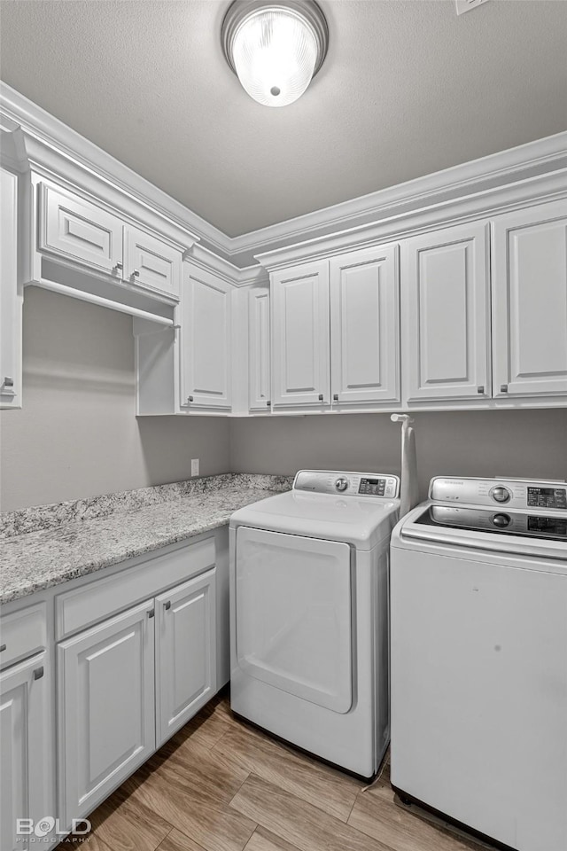 laundry room with separate washer and dryer and cabinets