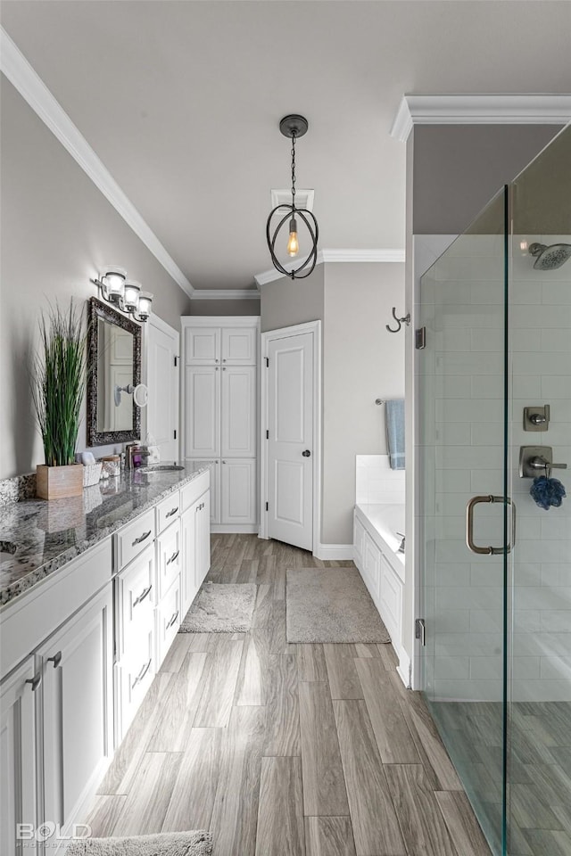 bathroom featuring shower with separate bathtub, ornamental molding, and vanity