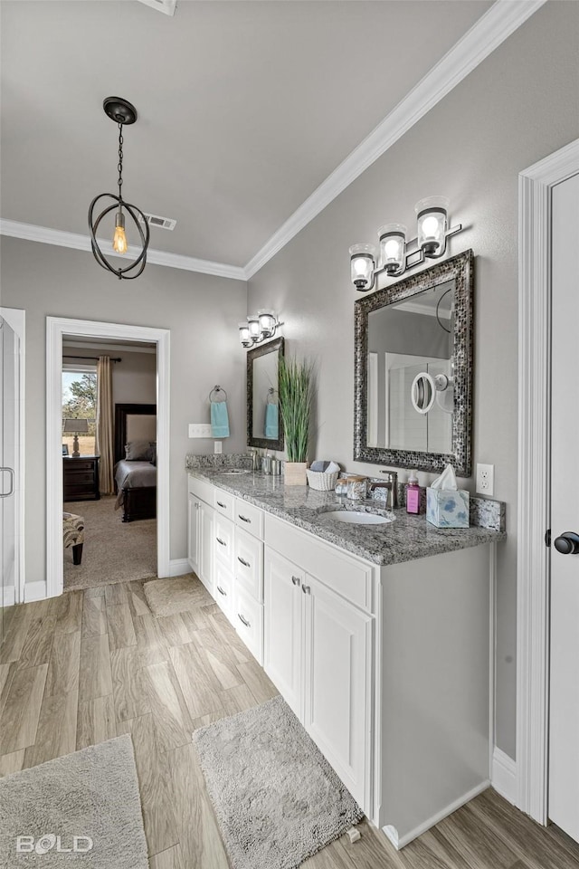 bathroom featuring ornamental molding, vanity, and hardwood / wood-style floors