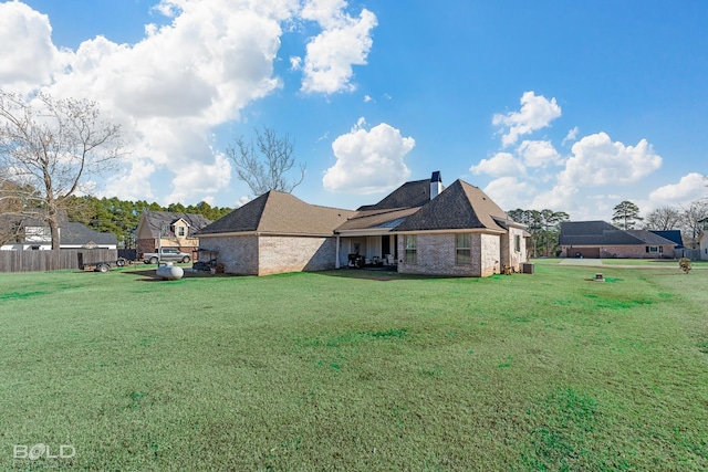 rear view of house featuring a lawn and central air condition unit