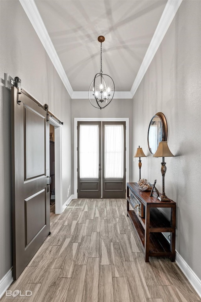 doorway to outside featuring a notable chandelier, crown molding, light wood-type flooring, and a barn door