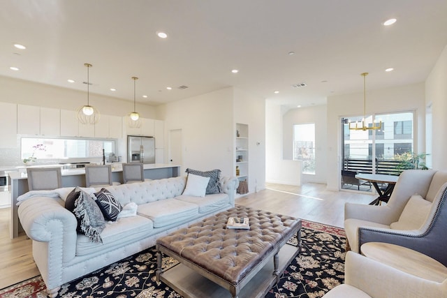 living room featuring an inviting chandelier and light hardwood / wood-style floors