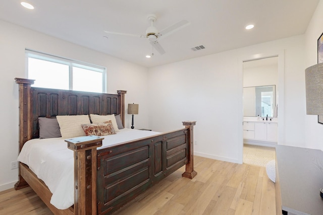 bedroom with ceiling fan, light wood-type flooring, ensuite bathroom, and sink