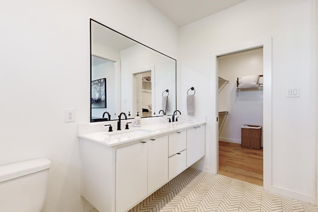 bathroom with toilet, vanity, and tile patterned floors