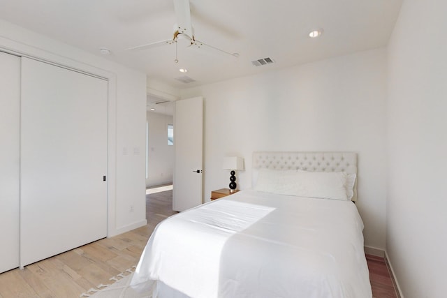 bedroom with a closet, ceiling fan, and light hardwood / wood-style floors