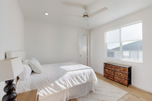 bedroom with ceiling fan, light wood-type flooring, and multiple windows