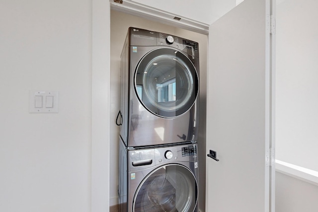 laundry room with stacked washing maching and dryer