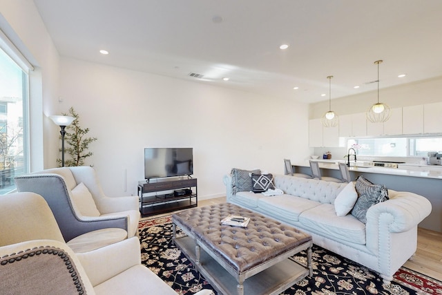 living room featuring sink and light hardwood / wood-style flooring