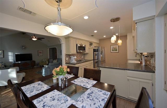 dining space with sink, ceiling fan, and dark wood-type flooring